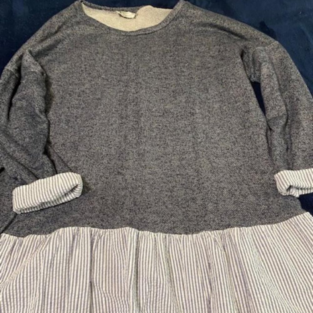 Women's long sleeved top. Has blue and white ruffle around the bottom of shirt.